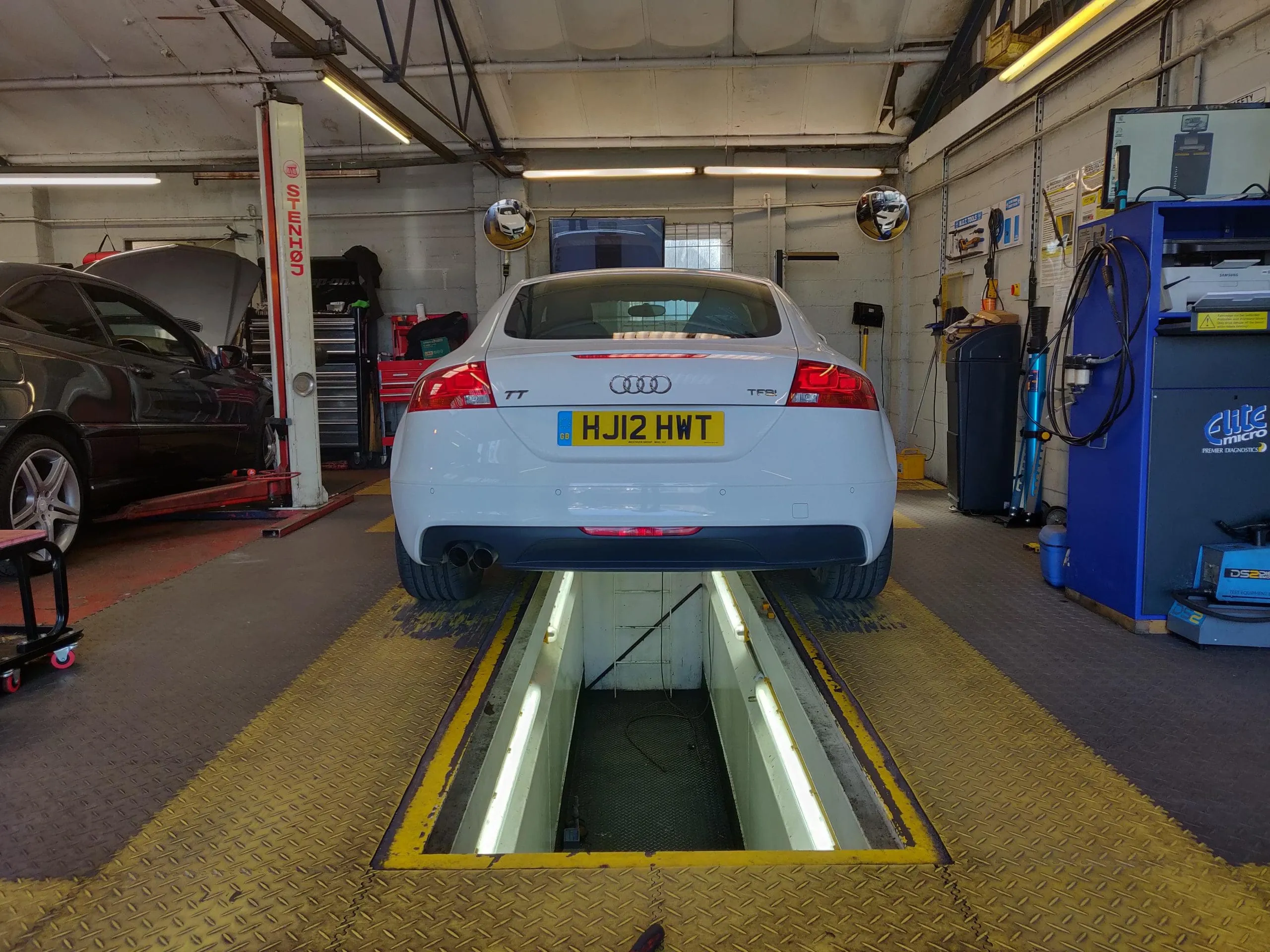 An Audi TT over the MOT pit